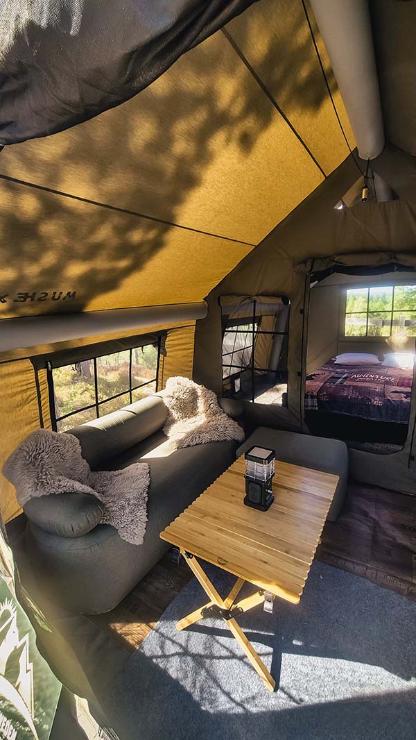 Pripučiama palapinė MIŠKAS PLUS Glamping interjeras su pripučiama sofa